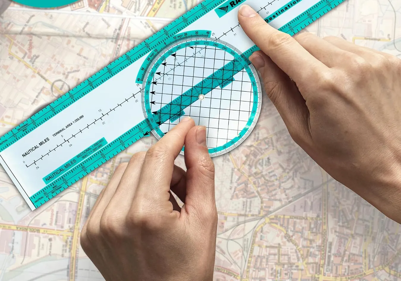 Hands rotating the plotter's azimuth over a sectional chart