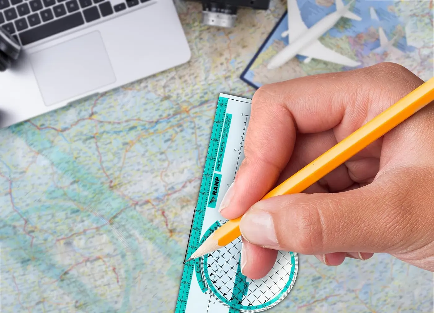 Hand drawing a course line on a chart with the rotating plotter